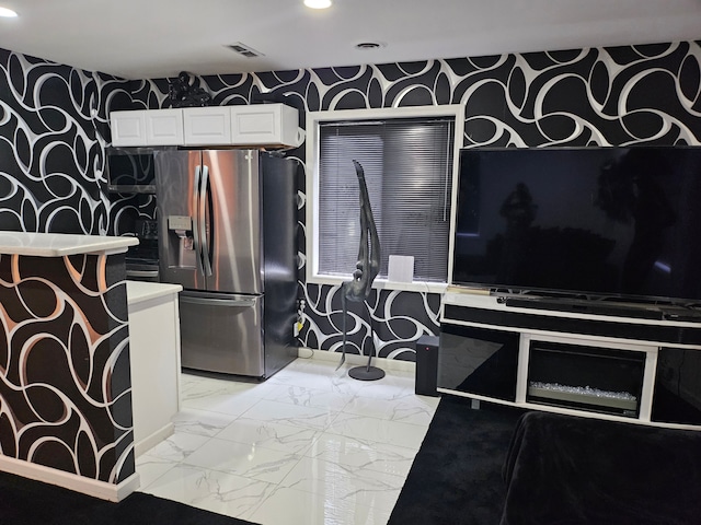 kitchen featuring white cabinetry and stainless steel fridge with ice dispenser