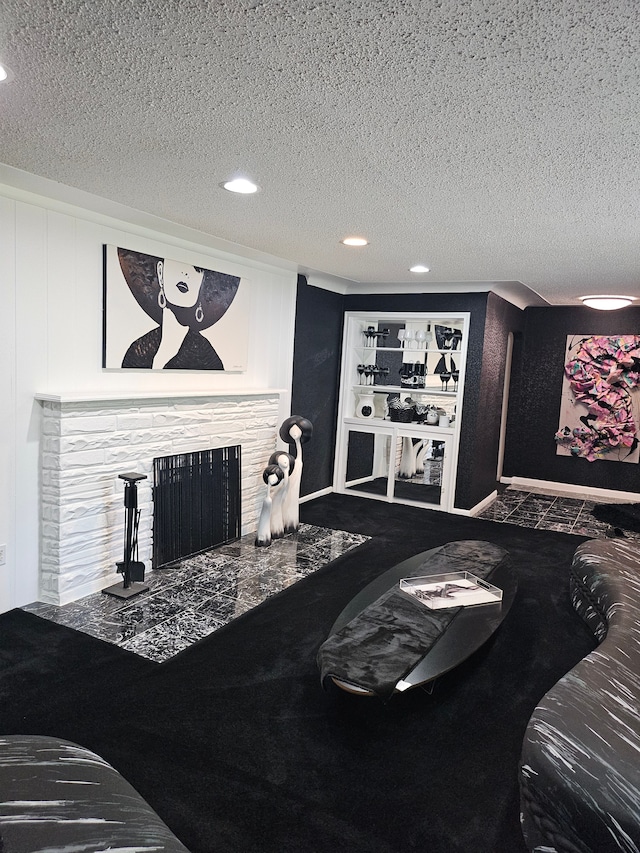 living room with a stone fireplace and a textured ceiling