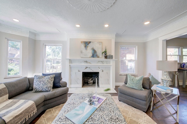 living room featuring a high end fireplace, wood-type flooring, a textured ceiling, and ornamental molding