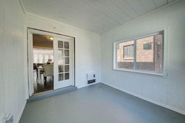 empty room featuring ornamental molding, heating unit, concrete floors, and french doors