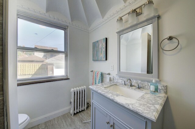 17566 Monica St, Detroit, MI 48221 - bathroom featuring radiator, toilet, vanity, wood finished floors, and baseboards