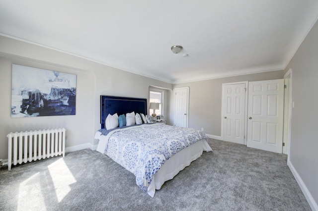 carpeted bedroom with radiator, crown molding, and two closets