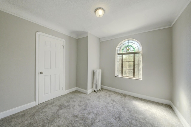 unfurnished room with light colored carpet, ornamental molding, radiator, and a textured ceiling