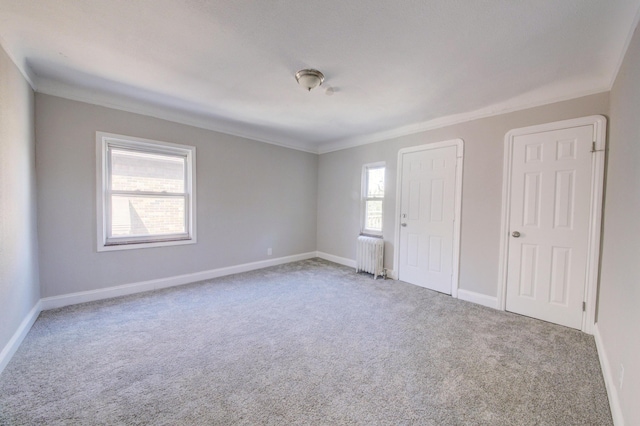 spare room featuring ornamental molding, carpet flooring, and radiator heating unit