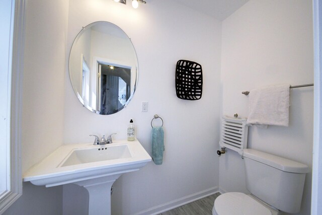 bathroom with hardwood / wood-style floors and toilet