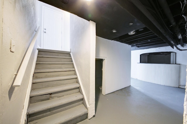 staircase featuring concrete floors