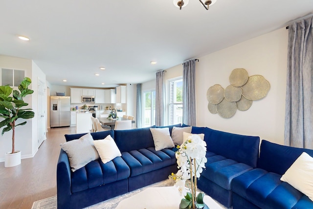 living room featuring recessed lighting, light wood-style flooring, baseboards, and visible vents