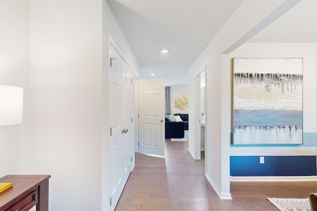 hallway featuring recessed lighting, wood finished floors, and baseboards