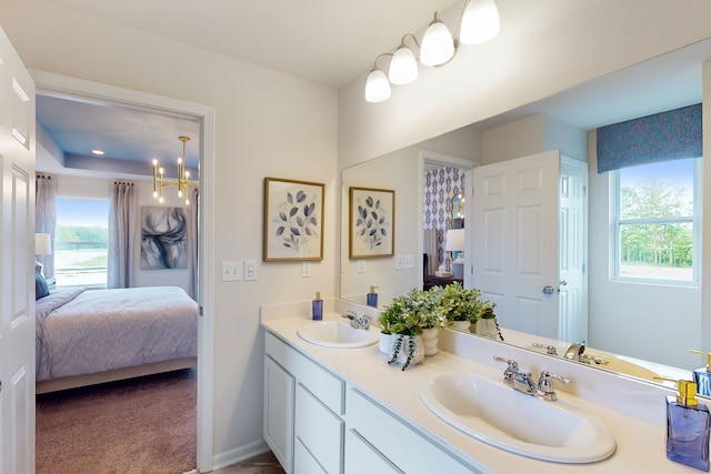 bathroom with plenty of natural light, connected bathroom, and a sink