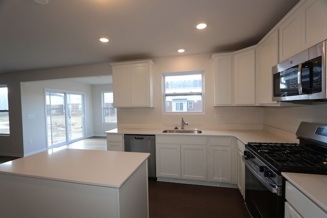 kitchen with dark wood-style floors, recessed lighting, a sink, stainless steel appliances, and white cabinets