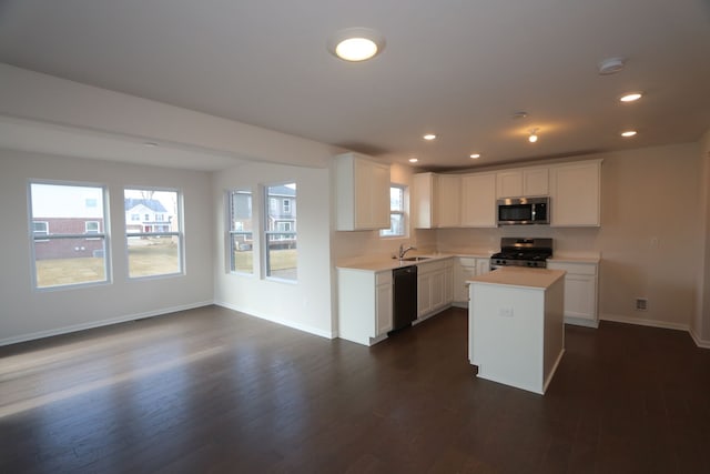 kitchen with baseboards, dark wood-type flooring, appliances with stainless steel finishes, and light countertops