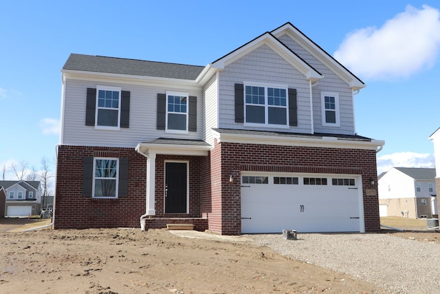 view of front of property featuring driveway, brick siding, and an attached garage