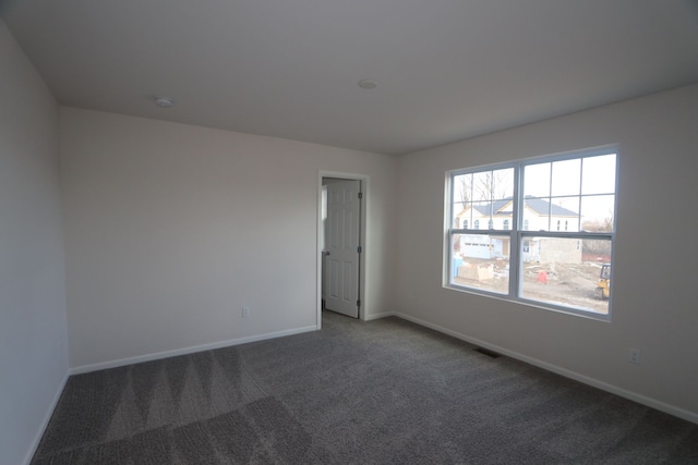 empty room featuring visible vents, baseboards, and carpet floors