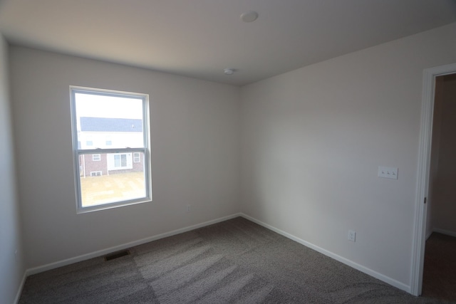 carpeted empty room with visible vents and baseboards