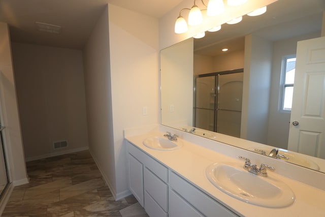 full bathroom with visible vents, a shower stall, baseboards, and a sink