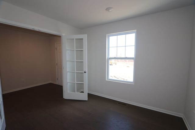 unfurnished bedroom featuring visible vents, baseboards, and dark wood finished floors