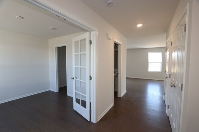 hallway featuring baseboards and dark wood-style flooring