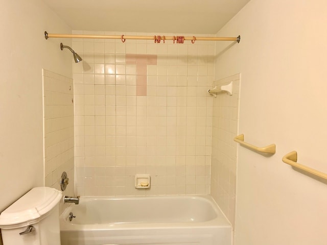 bathroom with tiled shower / bath combo and toilet