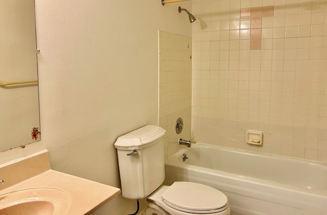 full bathroom featuring vanity, tiled shower / bath combo, and toilet