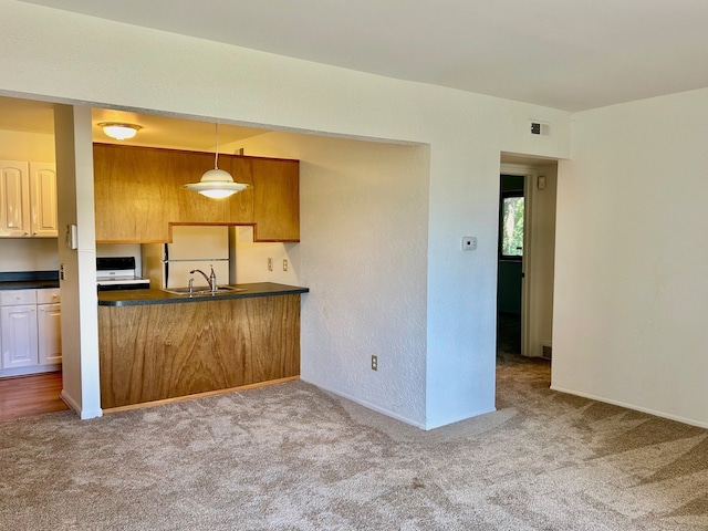 kitchen with light carpet, white appliances, and hanging light fixtures