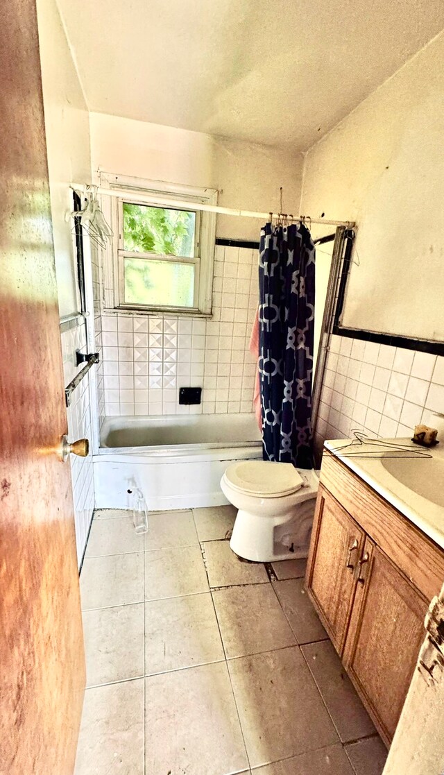 19685 Teppert St, Detroit, MI 48234 - full bathroom featuring tile walls, tile patterned flooring, toilet, shower / bathtub combination with curtain, and vanity