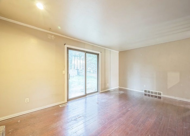 spare room with ornamental molding and hardwood / wood-style flooring