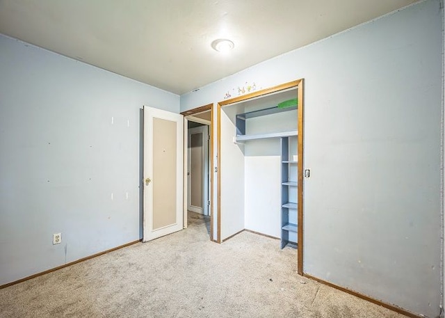 unfurnished bedroom featuring light carpet and a closet