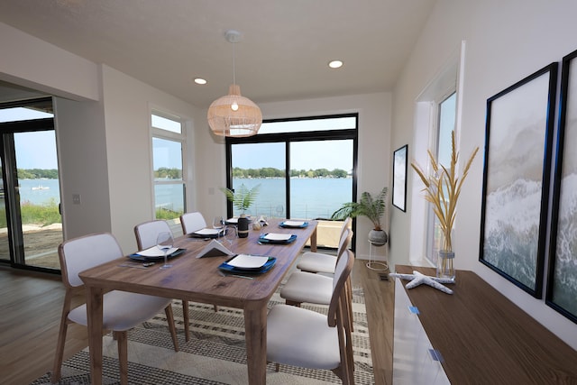 dining space with a water view and dark hardwood / wood-style floors