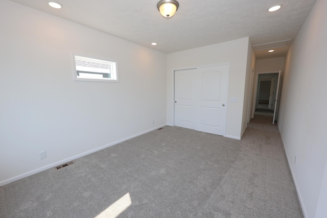 unfurnished bedroom with a closet and light colored carpet