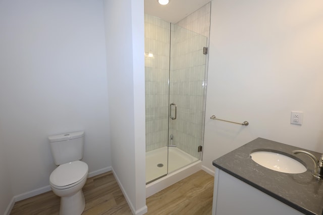 bathroom with toilet, an enclosed shower, vanity, and wood-type flooring