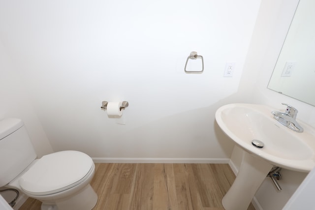 bathroom with toilet and hardwood / wood-style flooring