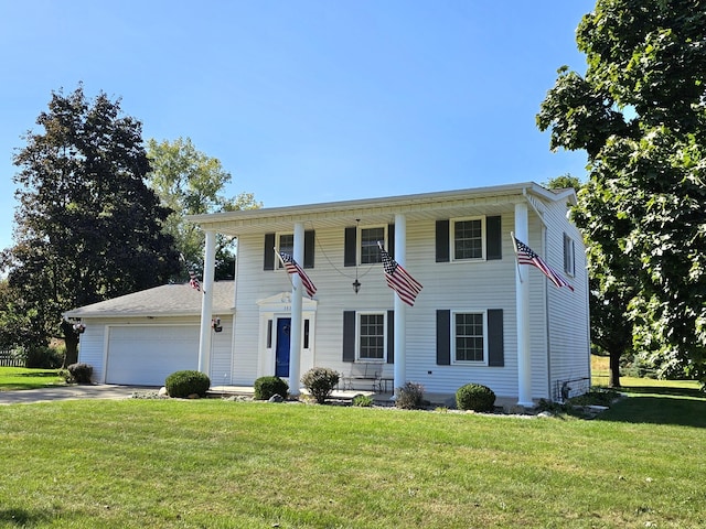 colonial house featuring a front yard and a garage