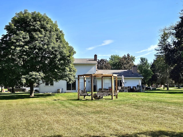 rear view of house featuring a lawn and a pergola