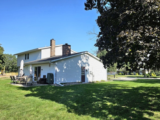 back of property with a lawn and a patio