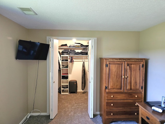 carpeted bedroom featuring a closet and a textured ceiling