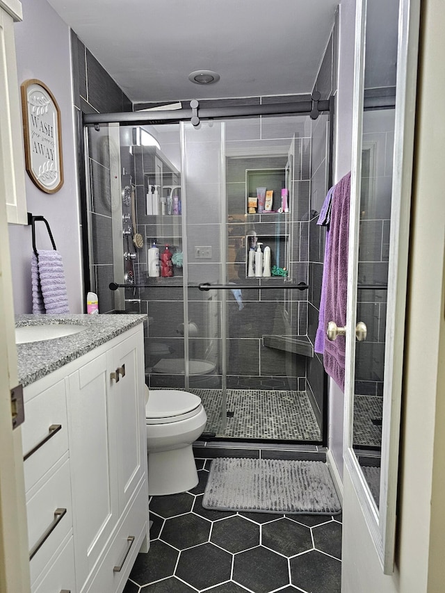 bathroom featuring vanity, toilet, and walk in shower