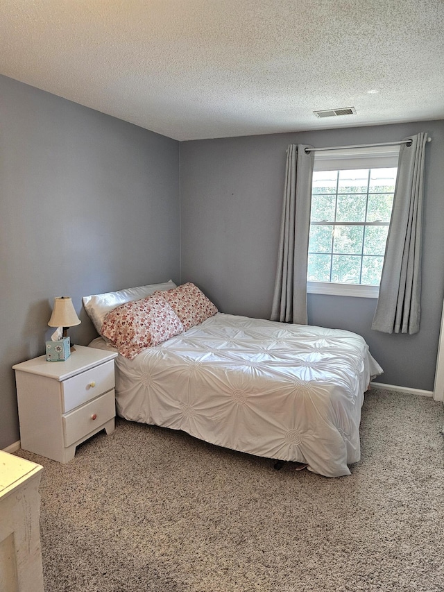 carpeted bedroom featuring a textured ceiling