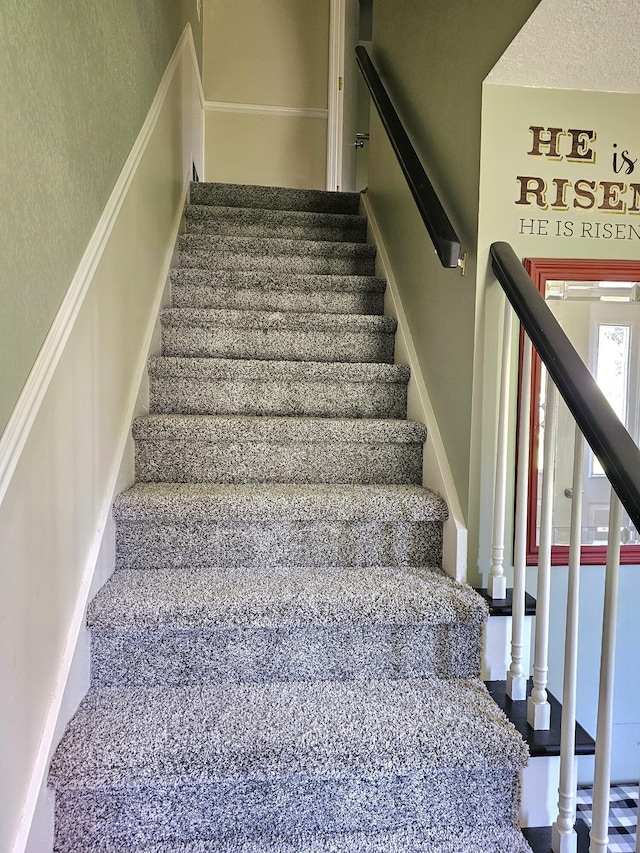 stairs with a textured ceiling