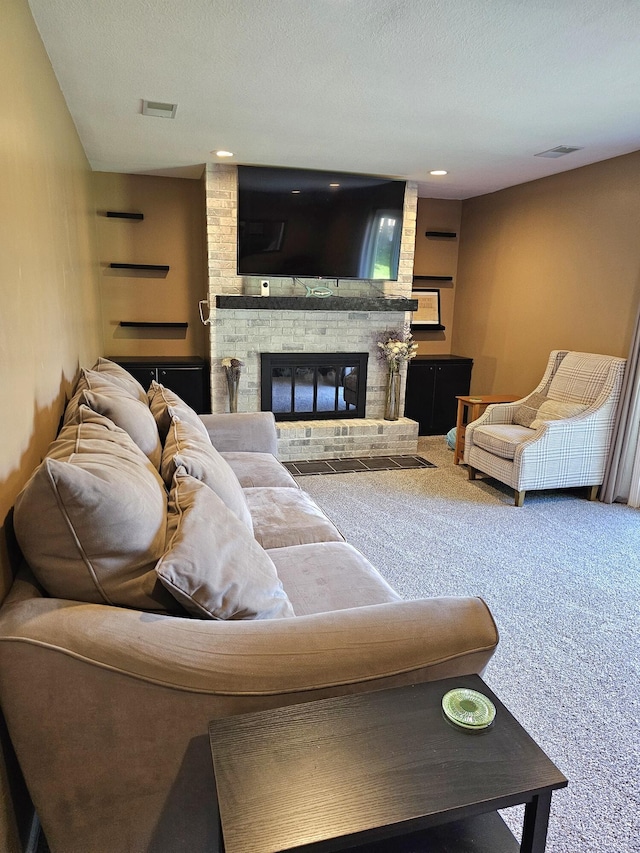 living room featuring carpet, a textured ceiling, and a brick fireplace