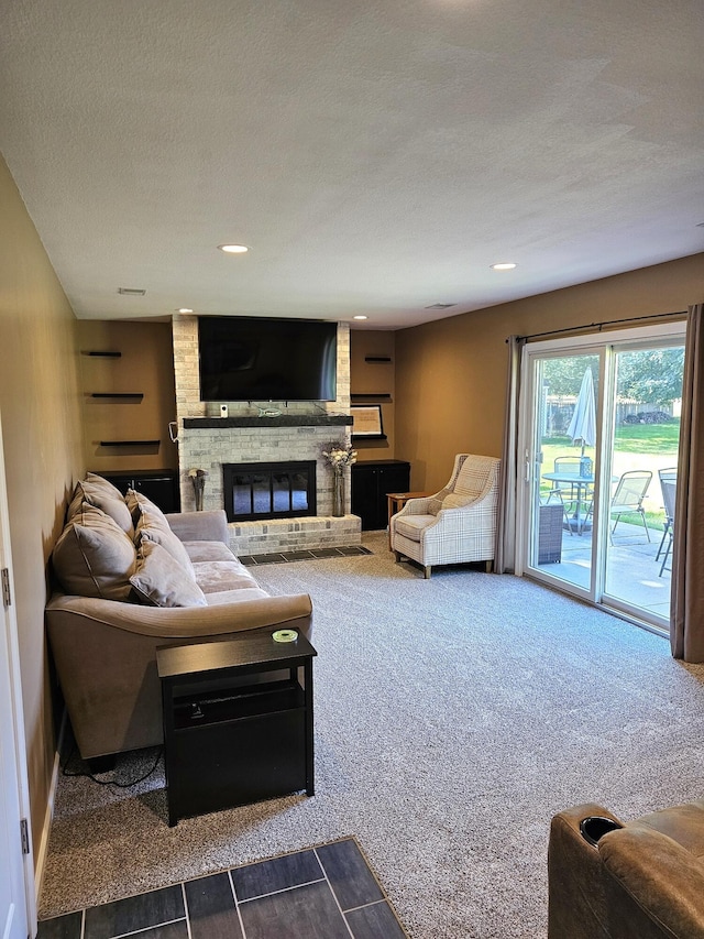 living room with carpet flooring, a textured ceiling, and a brick fireplace