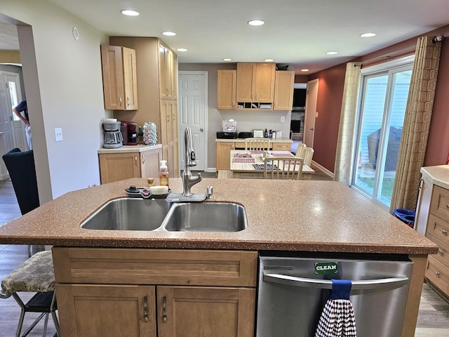 kitchen with a healthy amount of sunlight, sink, a center island with sink, dishwasher, and hardwood / wood-style floors