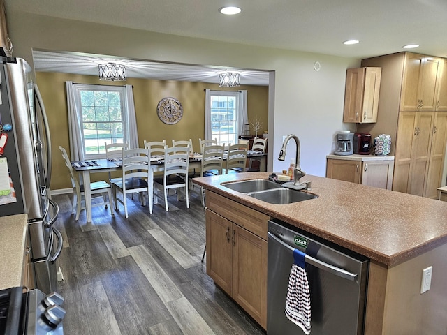 kitchen featuring a kitchen island with sink, dark wood-type flooring, sink, a notable chandelier, and stainless steel appliances