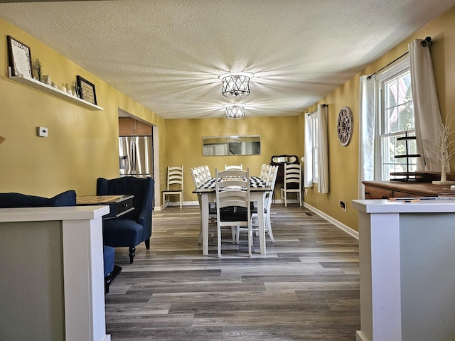 dining space with hardwood / wood-style floors and a textured ceiling