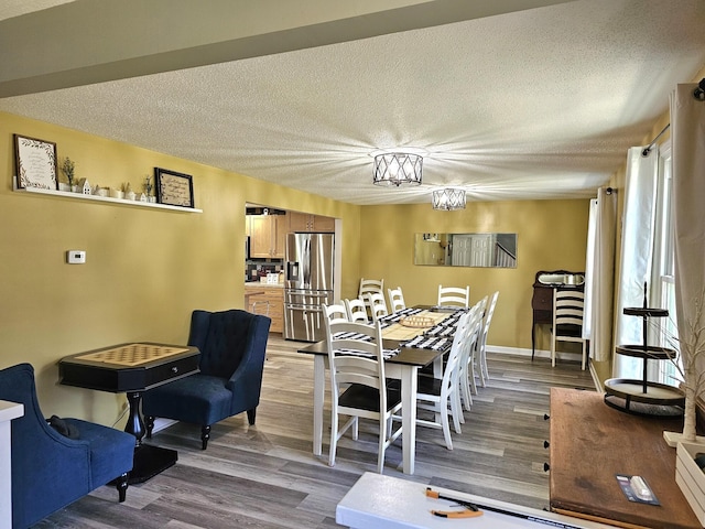 dining room with light hardwood / wood-style floors and a textured ceiling