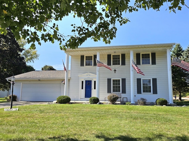 colonial-style house featuring a garage and a front lawn