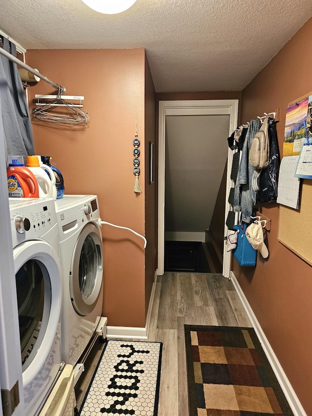 washroom featuring washer and dryer, hardwood / wood-style floors, and a textured ceiling