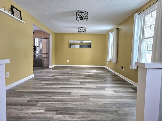 unfurnished dining area with a textured ceiling and light hardwood / wood-style flooring