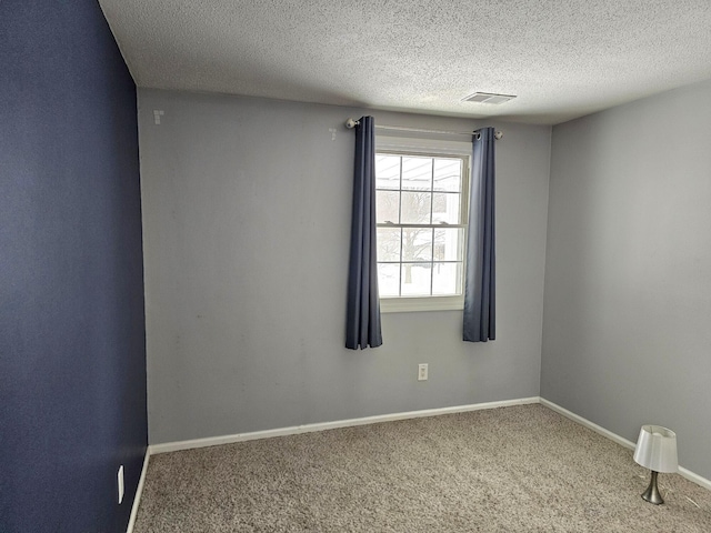 carpeted spare room with a textured ceiling