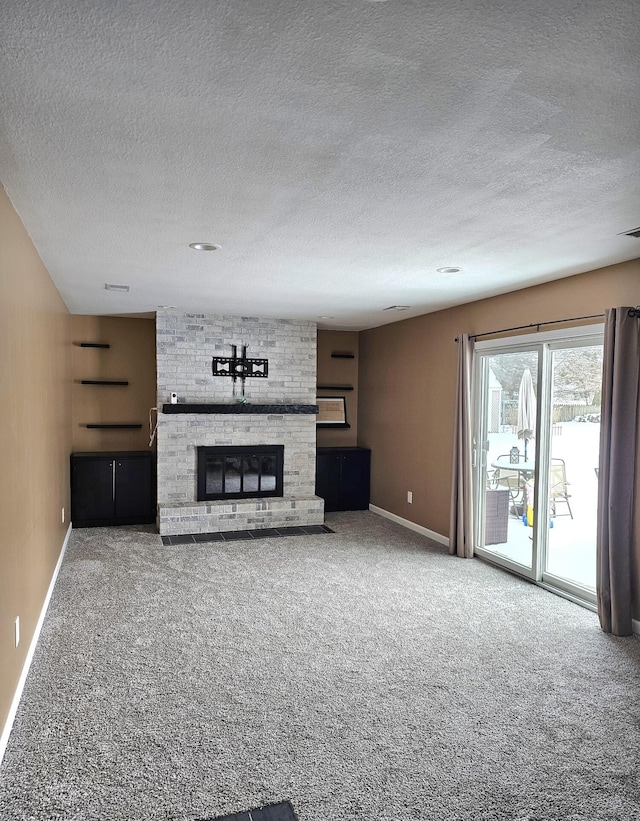 unfurnished living room with a large fireplace and carpet