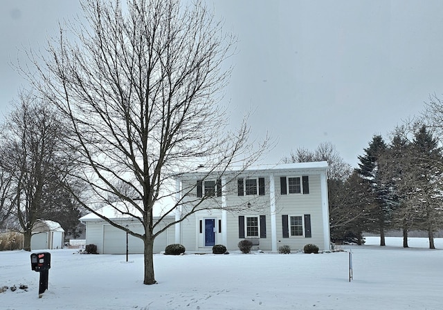 colonial inspired home featuring an outbuilding and a garage